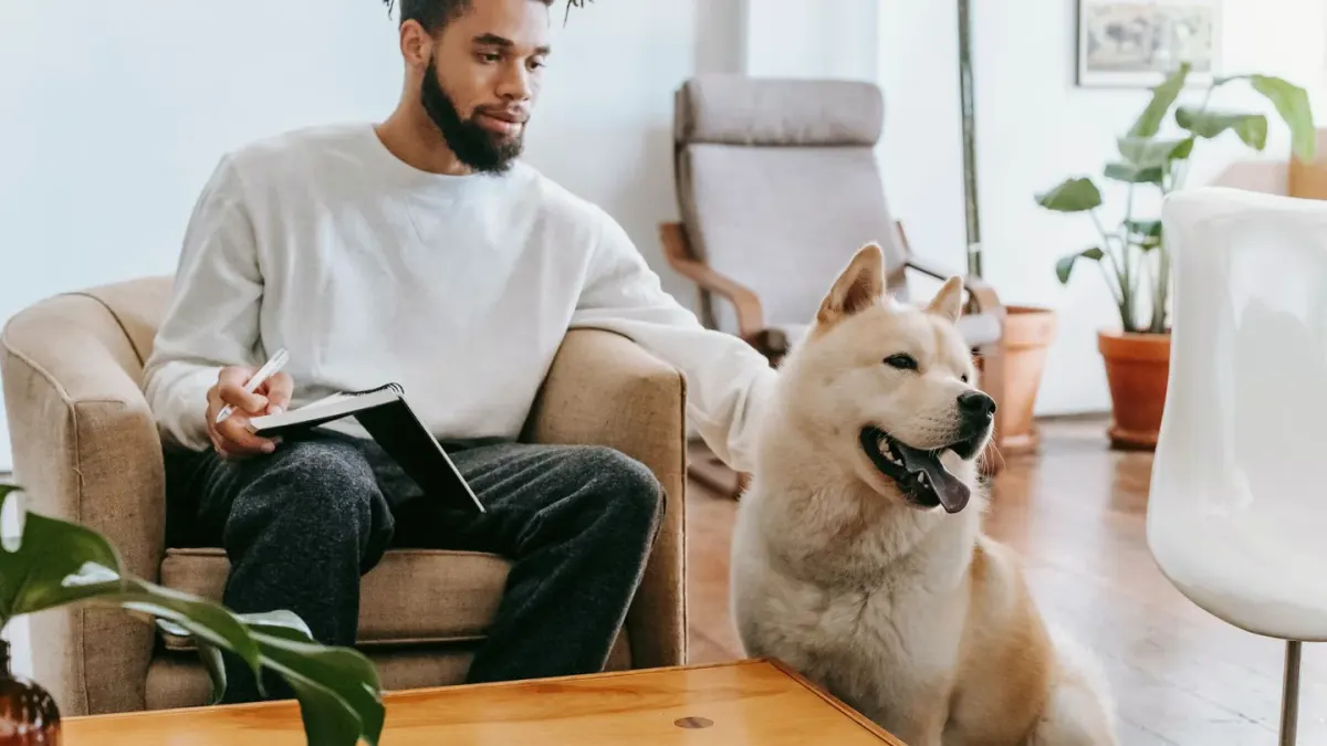 A dog owner kneeling to calm a nervous dog in a veterinary waiting room