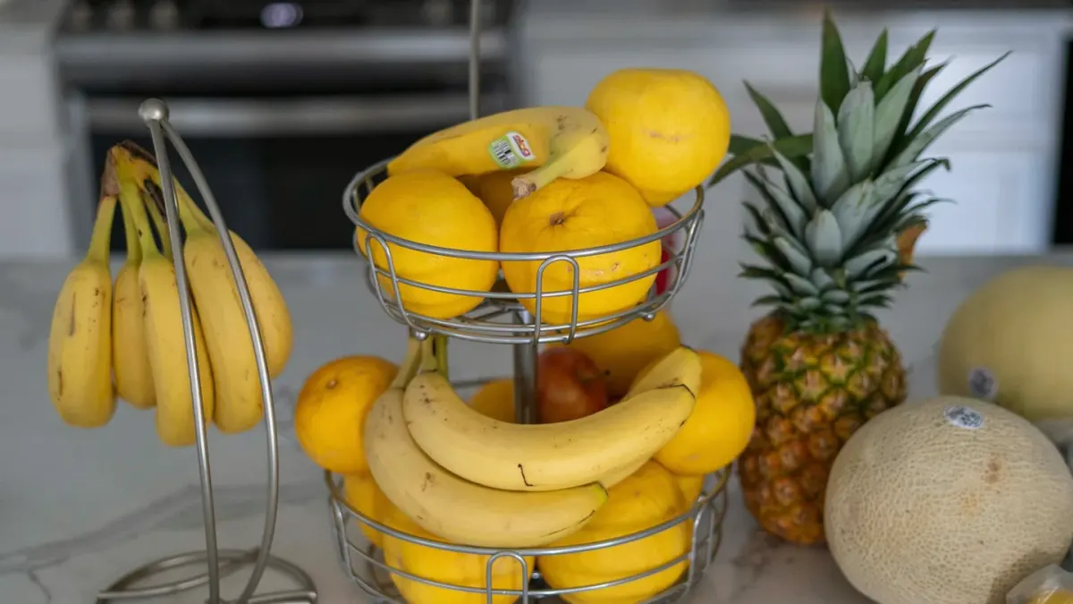 A dog sniffing a peeled banana resting on a kitchen counter