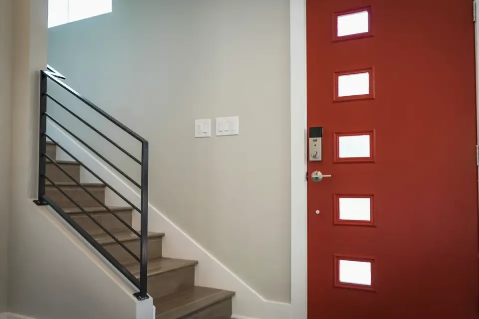 A dog standing and barking near a closed front door