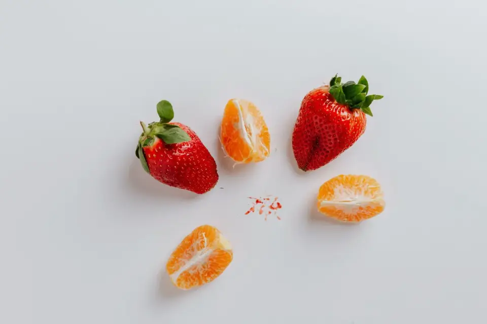 A person slicing fresh strawberries into small pieces for a dog treat