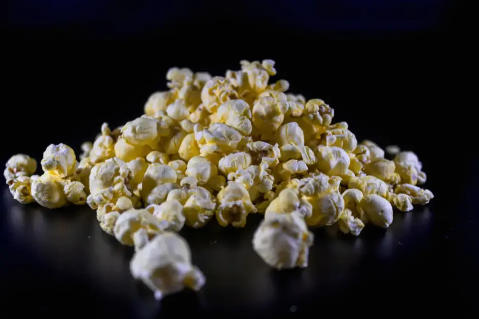 Close-up of several unpopped popcorn kernels resting in an open hand
