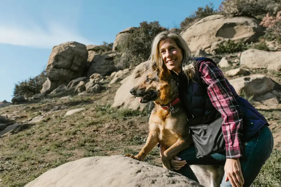 Owner running hands through a dog's fur checking for ticks after a hike