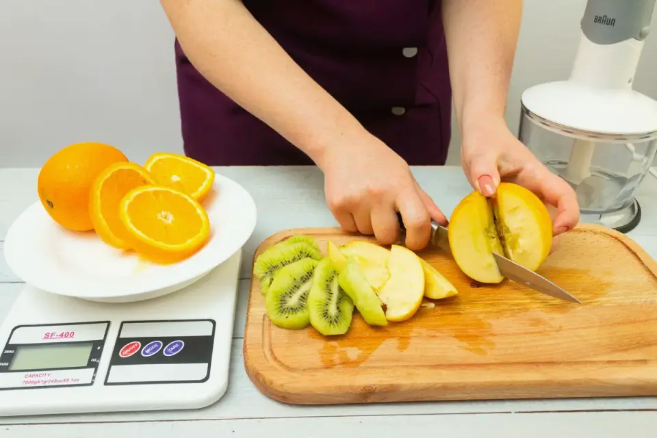 Owner slicing an apple into small pieces on a cutting board